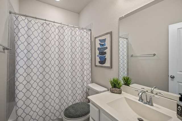 bathroom featuring toilet, a shower with shower curtain, and vanity