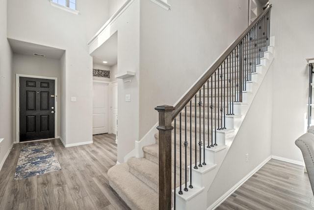 foyer with a high ceiling and light hardwood / wood-style floors