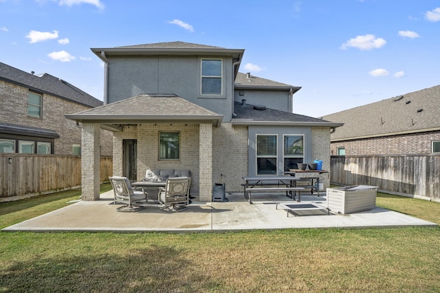 back of property with a patio area and a yard