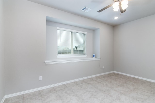 spare room with ceiling fan, visible vents, and baseboards