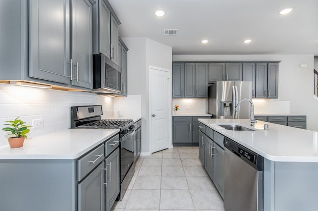 kitchen with stainless steel appliances, light countertops, visible vents, gray cabinetry, and a sink