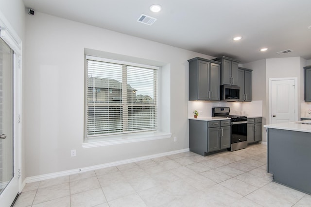 kitchen with light countertops, appliances with stainless steel finishes, visible vents, and gray cabinetry