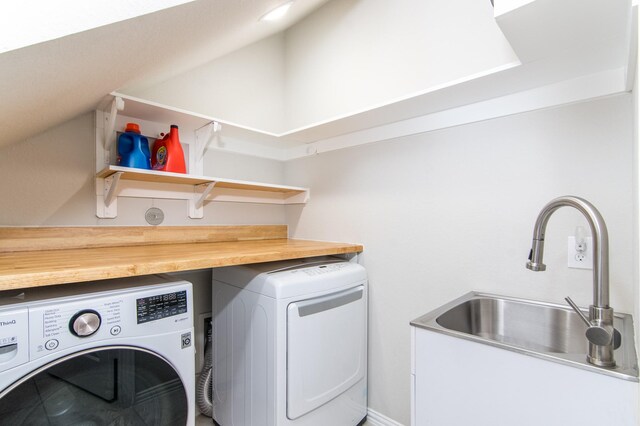 laundry room with laundry area, washing machine and dryer, and a sink