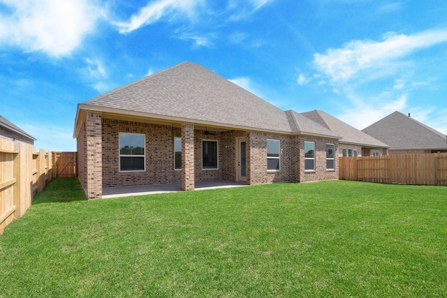 rear view of property featuring a patio and a yard