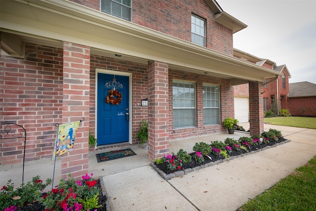 property entrance featuring covered porch and a garage