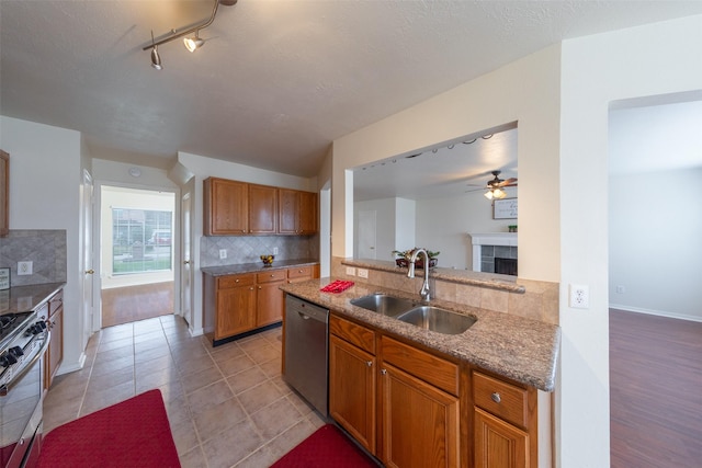 kitchen featuring a fireplace, appliances with stainless steel finishes, tasteful backsplash, and sink