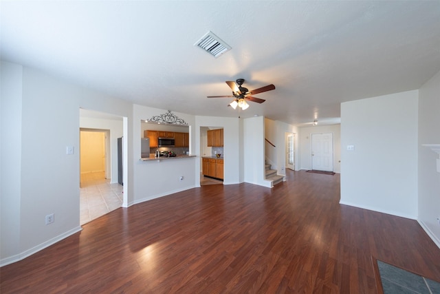 unfurnished living room with ceiling fan and dark hardwood / wood-style flooring