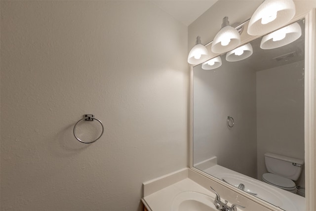 bathroom featuring toilet and vanity