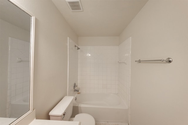 bathroom with toilet and tiled shower / bath combo