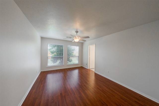 empty room with ceiling fan and dark hardwood / wood-style floors