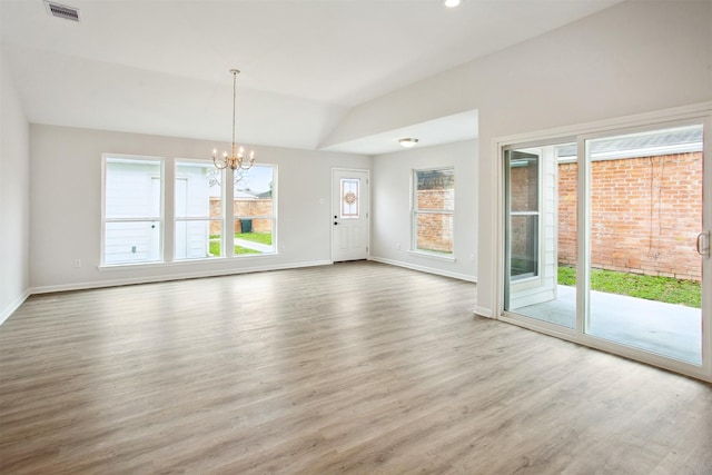 interior space with vaulted ceiling, a chandelier, and plenty of natural light