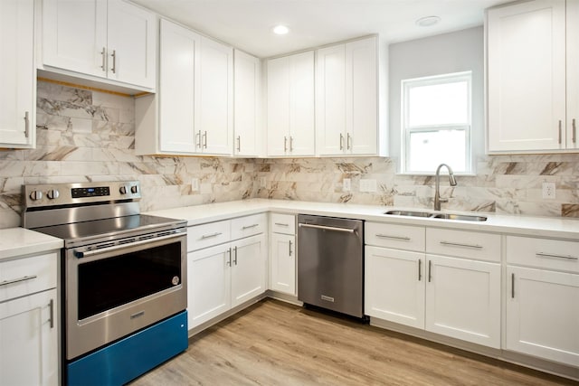 kitchen with stainless steel appliances, white cabinets, tasteful backsplash, and sink