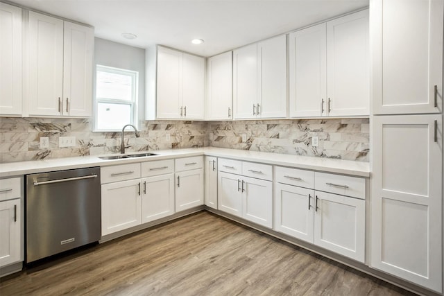 kitchen with dishwasher, light hardwood / wood-style flooring, decorative backsplash, white cabinets, and sink