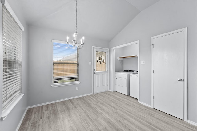 unfurnished dining area featuring washer and dryer, light hardwood / wood-style floors, lofted ceiling, and a chandelier