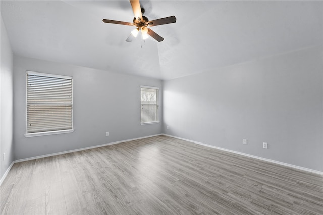 spare room featuring ceiling fan, light wood-type flooring, and lofted ceiling