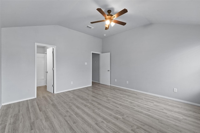 unfurnished bedroom featuring vaulted ceiling, ensuite bathroom, light wood-type flooring, and ceiling fan