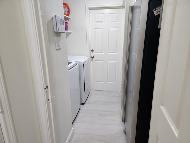 washroom featuring washing machine and dryer and light wood-type flooring