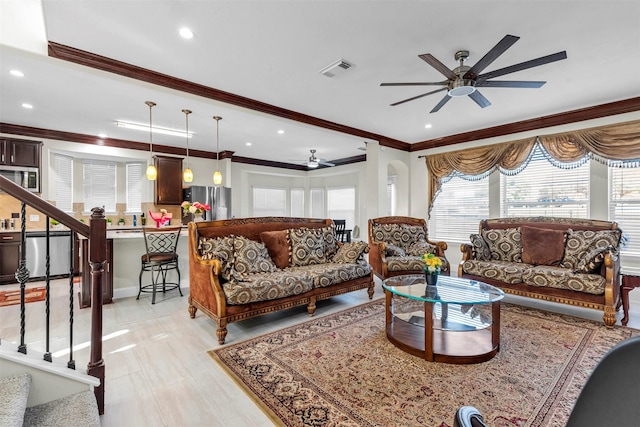 living room with ceiling fan and ornamental molding