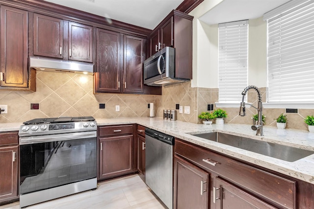 kitchen with light stone countertops, sink, light tile patterned floors, and stainless steel appliances