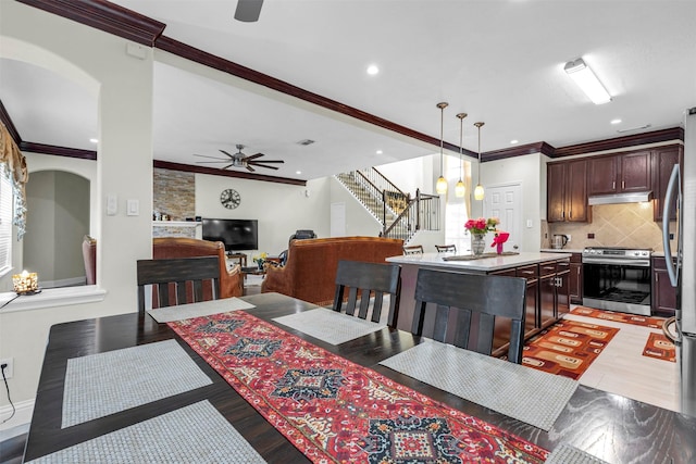 dining area featuring ceiling fan, ornamental molding, and light wood-type flooring