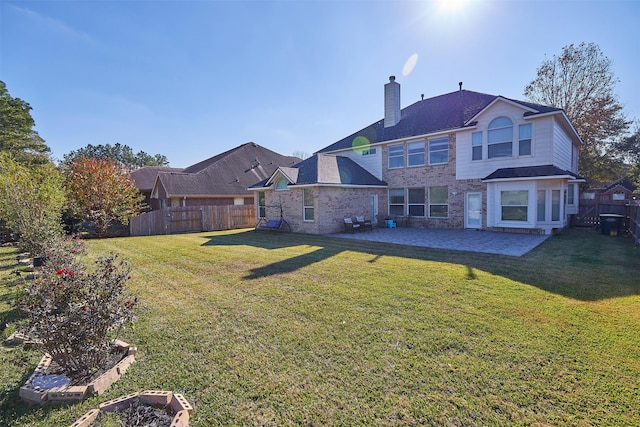 rear view of house featuring a yard and a patio