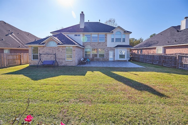 rear view of house featuring a lawn and a patio