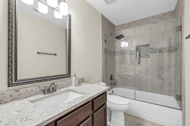 full bathroom with toilet, vanity, and shower / bath combination with glass door