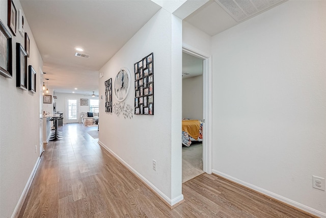 hallway with light hardwood / wood-style flooring