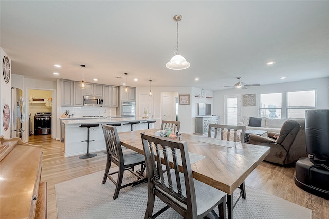 dining area featuring ceiling fan, light hardwood / wood-style floors, and sink