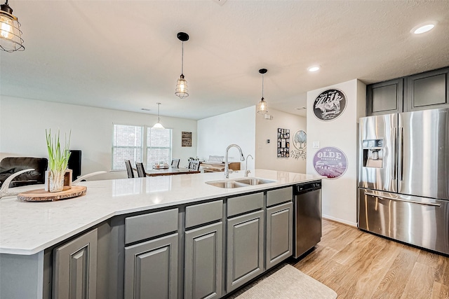 kitchen with sink, a center island with sink, gray cabinetry, and appliances with stainless steel finishes