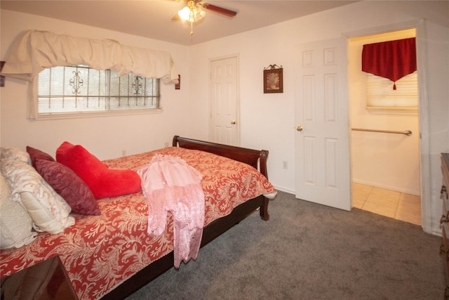 bedroom with dark carpet, a ceiling fan, and dark tile patterned flooring