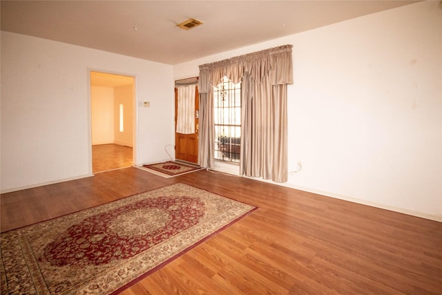 spare room featuring wood finished floors and visible vents