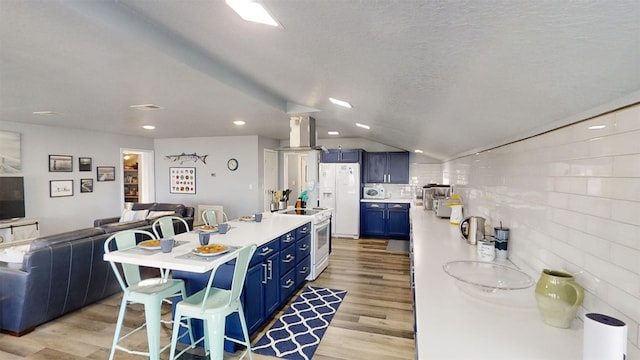 kitchen with a kitchen breakfast bar, blue cabinets, white appliances, and light hardwood / wood-style floors