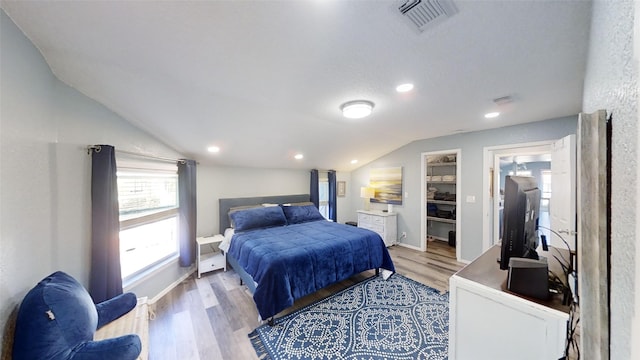 bedroom with lofted ceiling and light wood-type flooring