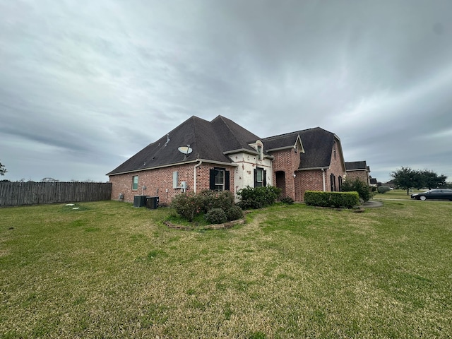 view of side of home with a lawn and central air condition unit