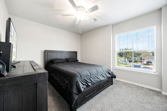 bedroom with ceiling fan, light colored carpet, and multiple windows