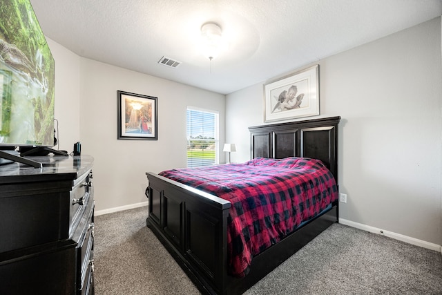 bedroom featuring dark carpet and a textured ceiling