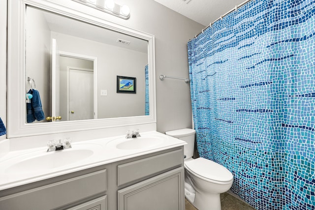 bathroom with toilet, a textured ceiling, curtained shower, and vanity