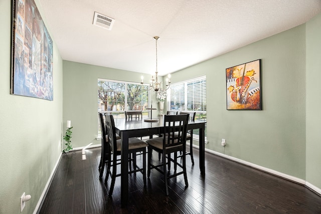 dining space with a notable chandelier and dark hardwood / wood-style floors