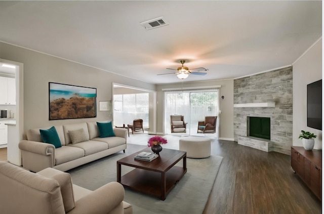 living room featuring dark hardwood / wood-style flooring, ceiling fan, and a tile fireplace