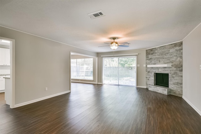 unfurnished living room featuring a fireplace, dark wood-type flooring, ceiling fan, and ornamental molding