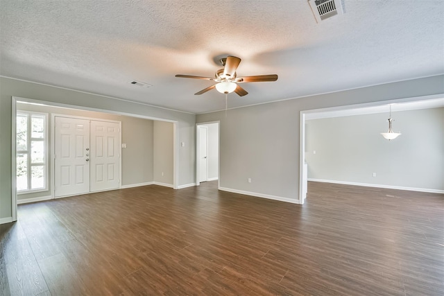 empty room with dark wood-type flooring, a textured ceiling, and ceiling fan