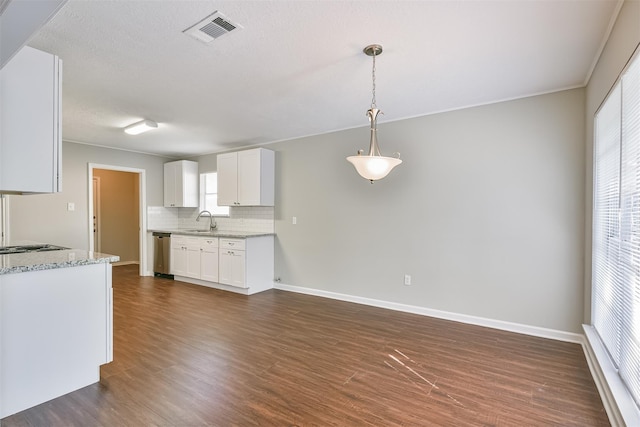 kitchen with white cabinetry, stainless steel dishwasher, decorative backsplash, hanging light fixtures, and light stone countertops