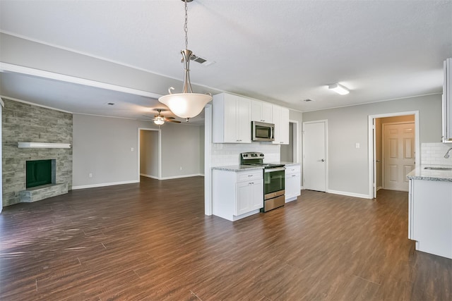 kitchen featuring stainless steel appliances, hanging light fixtures, ceiling fan, white cabinets, and tasteful backsplash