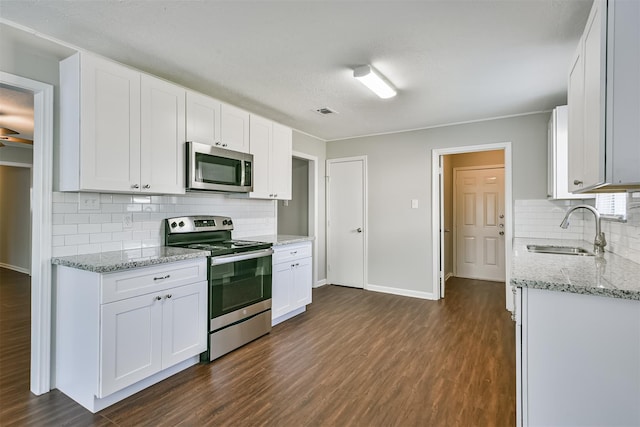 kitchen with white cabinets, appliances with stainless steel finishes, decorative backsplash, and sink