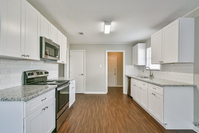 kitchen featuring stainless steel appliances, light stone countertops, white cabinets, and sink