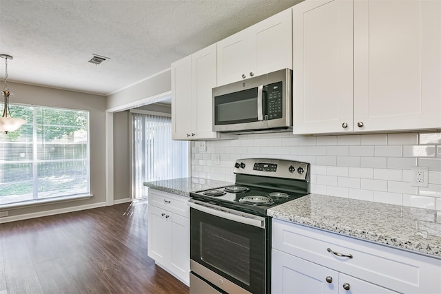 kitchen with light stone counters, stainless steel appliances, white cabinets, and pendant lighting