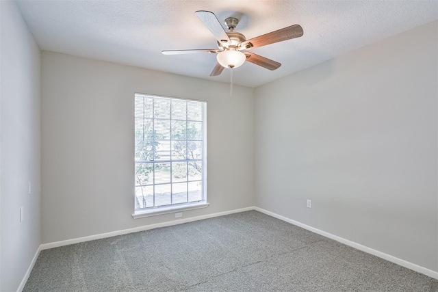 carpeted spare room with ceiling fan and a textured ceiling