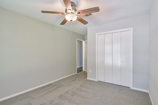 unfurnished bedroom with ceiling fan, light colored carpet, and a closet