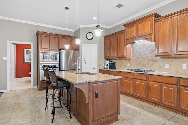 kitchen featuring stainless steel appliances, a kitchen island with sink, crown molding, and hanging light fixtures